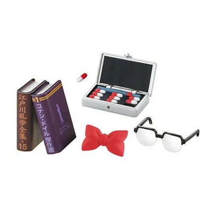 various objects, including a pair of glasses, a book, a box of pills, and a bow tie.
