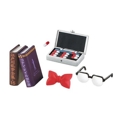 various objects, including a pair of glasses, a book, a box of pills, and a bow tie.