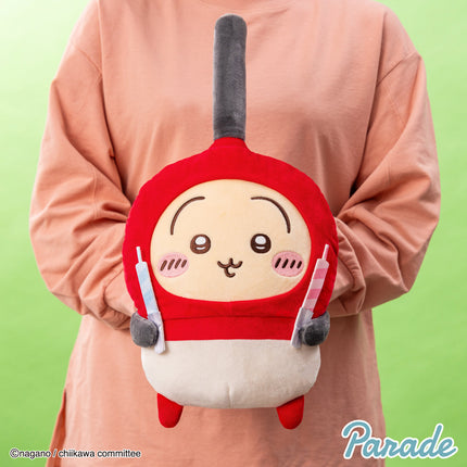 Red-and-white big plush toy with gray ear muffs and a smiling character face.