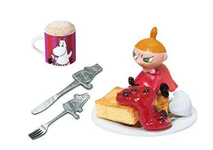 a collection of various objects, including a mug with a cartoon character, a figurine of a young girl, a cake, a fork, and a spoon.