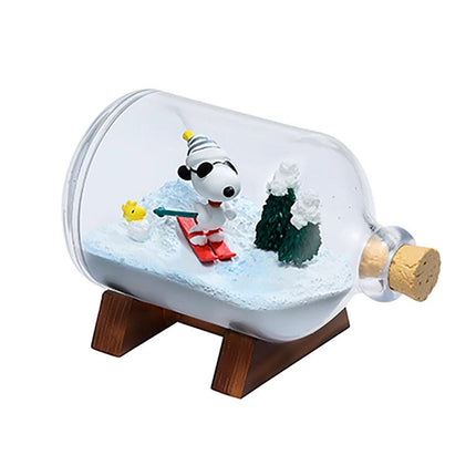 A miniature snow scene inside a glass bottle, featuring a character skiing on a snowy slope.