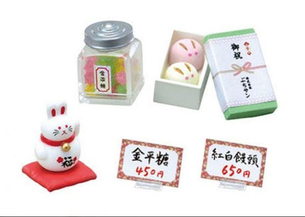 various items, including a small rabbit figurine, a glass jar, a box, and some signs with Japanese text.