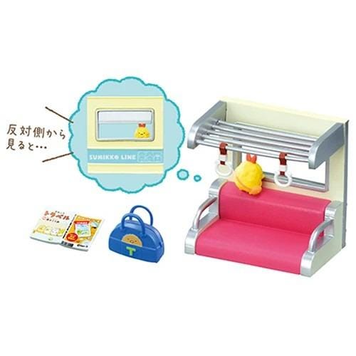 a toy train set with a pink bench, a blue purse, and a yellow bird. There is also a thought bubble containing a cartoon image of a train and a yellow bird.