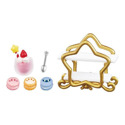 various desserts and a star-shaped holder, including a pink cup with a strawberry, macarons, and a cake.