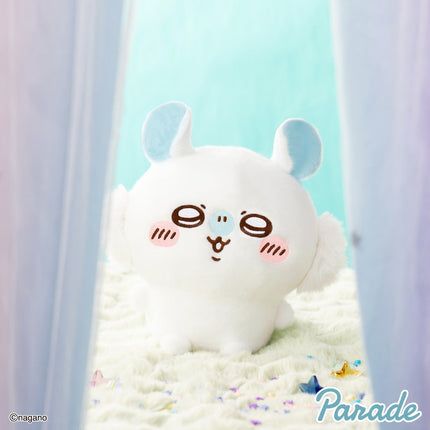 Super fluffy white plush toy with light-blue ears and an embroidered face, sitting on bedding
