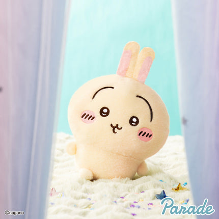 Super fluffy cream plush toy with pink ear accents and an embroidered face, sitting on bedding