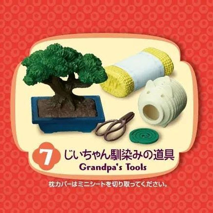 The image is a collage of various objects, including a small tree in a pot, a pair of scissors, a roll of paper towels, and a roll of toilet paper, all arranged on a red background.