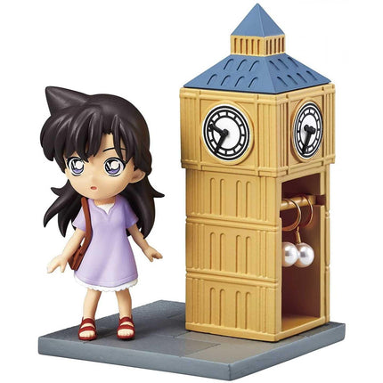 A figurine of a young girl standing next to a clock tower.