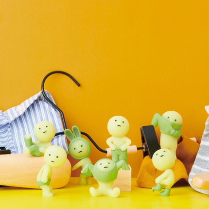 a group of small, glowing figurines arranged on a yellow surface against a bright orange background.