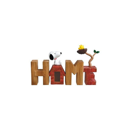 A wooden sign spelling out the word "HOME" with a Snoopy figurine sitting on top of a wooden house.