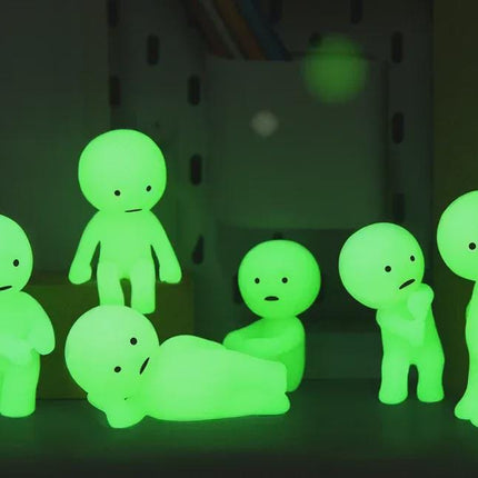 A group of small, glowing green figurines are arranged on a surface, creating a visually striking and ethereal display.