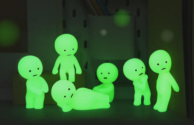 A group of small, glowing green figurines are arranged on a surface, creating a visually striking and ethereal display.