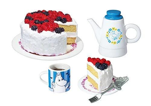 A cake with berries, a teapot, a mug with a cartoon character, and a fork are arranged on a white background.