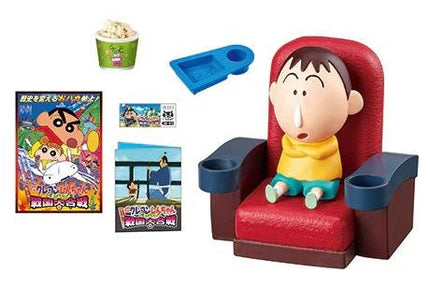 a toy figurine of a boy sitting in a red chair, a bowl of popcorn, and a blue tray. There is also a poster of a cartoon character and a small toy car.