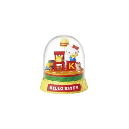 A Hello Kitty snow globe with a lamp, chair, and other decorative elements.