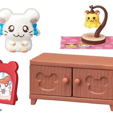various small toy figurines and furniture items, including a white mouse figurine, a yellow mouse figurine, a red bear-shaped picture frame, a brown wooden cabinet, and a pink polka dot rug.