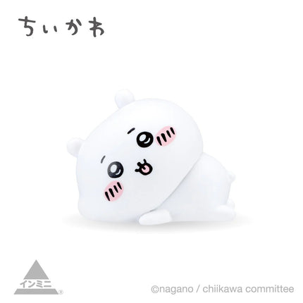 Interior mini figure, white seal-like character with open eyes, curled