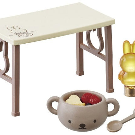 Dollhouse tea set with small table, golden rabbit figure, cup, and spoon accessory
