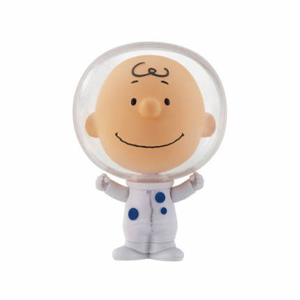 Astronaut capsule toy with clear helmet, smiling tan face, and white suit with blue dots
