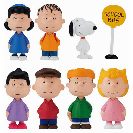 Seven Peanuts capsule toy character figures with Snoopy and a school bus sign, front view