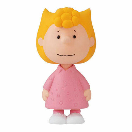 PEANUTS capsule toy figure of a girl in a pink dress with yellow hair
