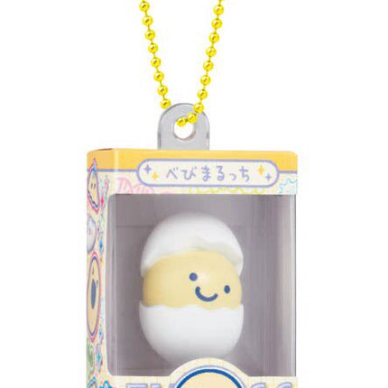 White and yellow character gumiture charm in box with yellow beaded keychain