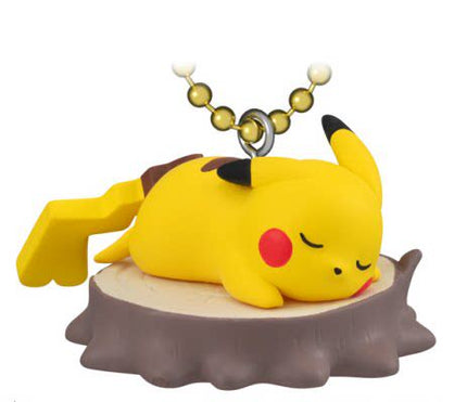 Pikachu mascot keychain with biscuit-themed charm, yellow plush figure on brown base