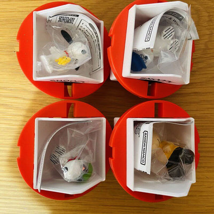 Four opened red capsule containers with packaged Snoopy-themed figures