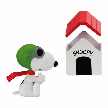 Snoopy figurine with green cap accessory and white house accessory labeled “SNOOPY”