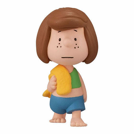 Peanuts-style girl figure holding a yellow item, green top, and blue shorts