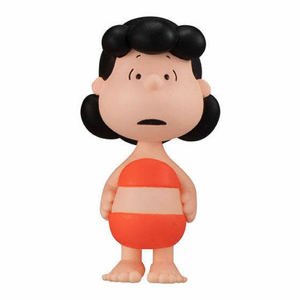 Peanuts-style girl figure with black pigtails and orange striped dress