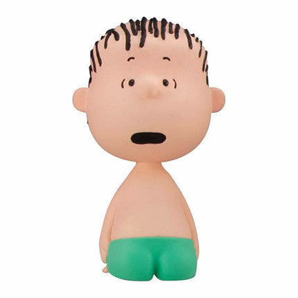 Peanuts-style boy figure with spiky hair and green shorts