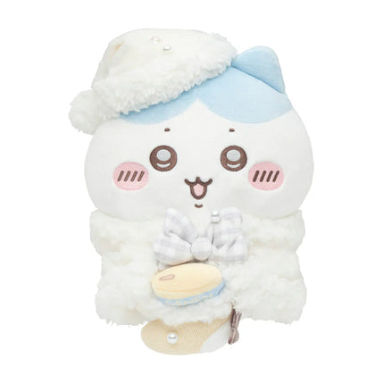 White plush character with blue hat, rosy cheeks, holding a tiny moon-themed item.