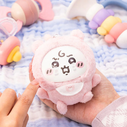 Small pink character plush toy with a printed face on the front
