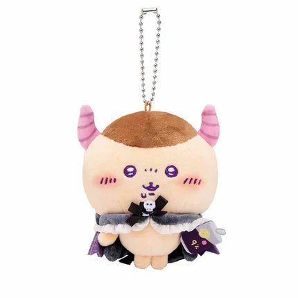 Round plush mascot keychain with tan head, purple face details, dark cloak, silver chain.