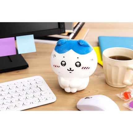Small white plush toy with blue cap, smiling face, and plush feet