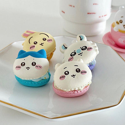 Macaron mascot toys on a tray: blue, yellow, white, and pink shell figures