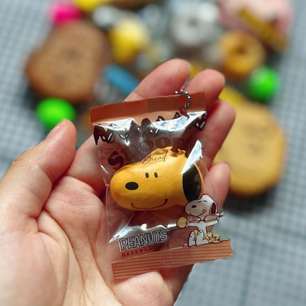 Single Peanuts bakery charm keychain showing Snoopy figure in a sealed plastic bag