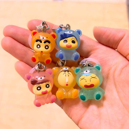 Five chibi pajama character keychains held in hands, with metal rings and clips