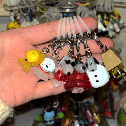 Assorted character keychain charms on metal rings held in a hand