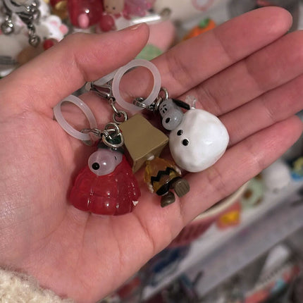 Close-up of character keychains on rings held in a hand