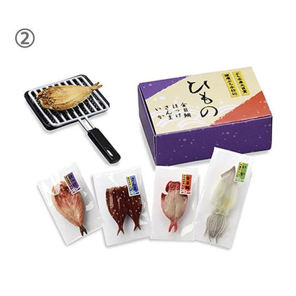 various packaged seafood items, including a small fish on a grill, a purple box, and several packages of different types of seafood.