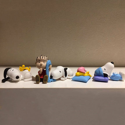 Snoopy sleeping figures set lined up on shelf on blue and yellow mats