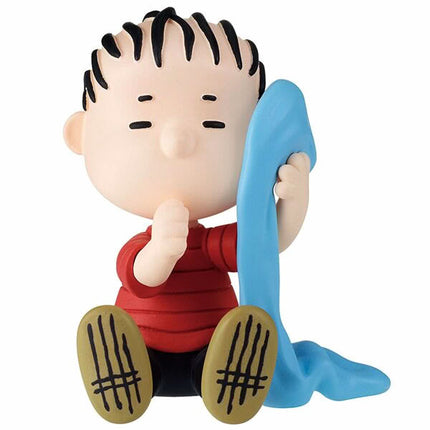 Character figure in red shirt holding a blue blanket, round face and striped hair
