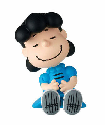 Linus-style capsule toy figure with dark hair and blue blanket, seated