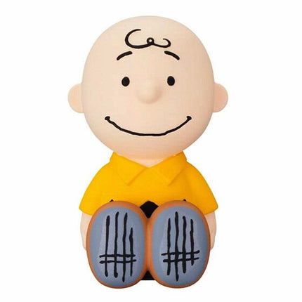 Beige-headed Charlie Brown-style capsule figure in yellow shirt with black line accents.