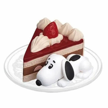 Red and cream cake slice capsule figure with Snoopy face, on round white plate