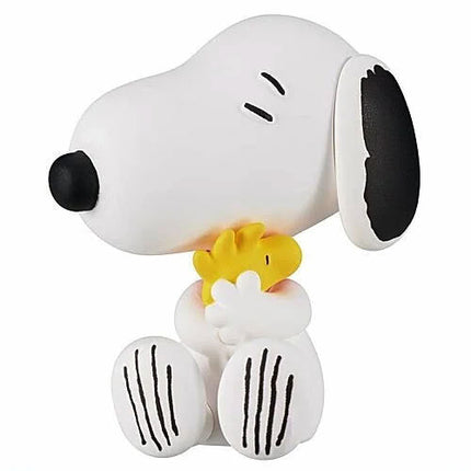 Snoopy figure holding a small yellow Woodstock, on a white support