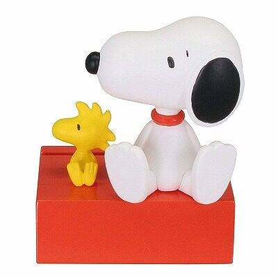 Snoopy mascot figurine lying on red base, holding a yellow star