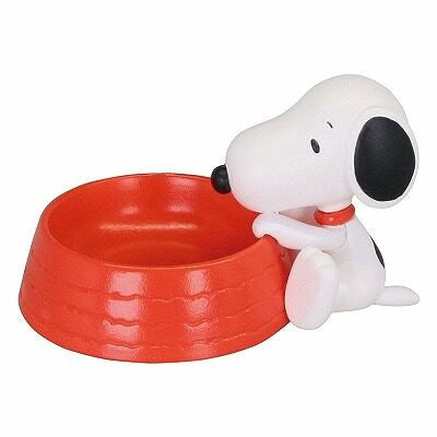 Snoopy mascot figurine sitting beside a red dog bowl